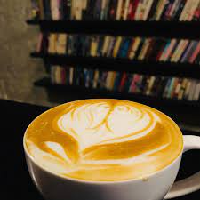 A latte in front of a book shelf.