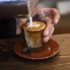 A person pouring a coffee into a cup.