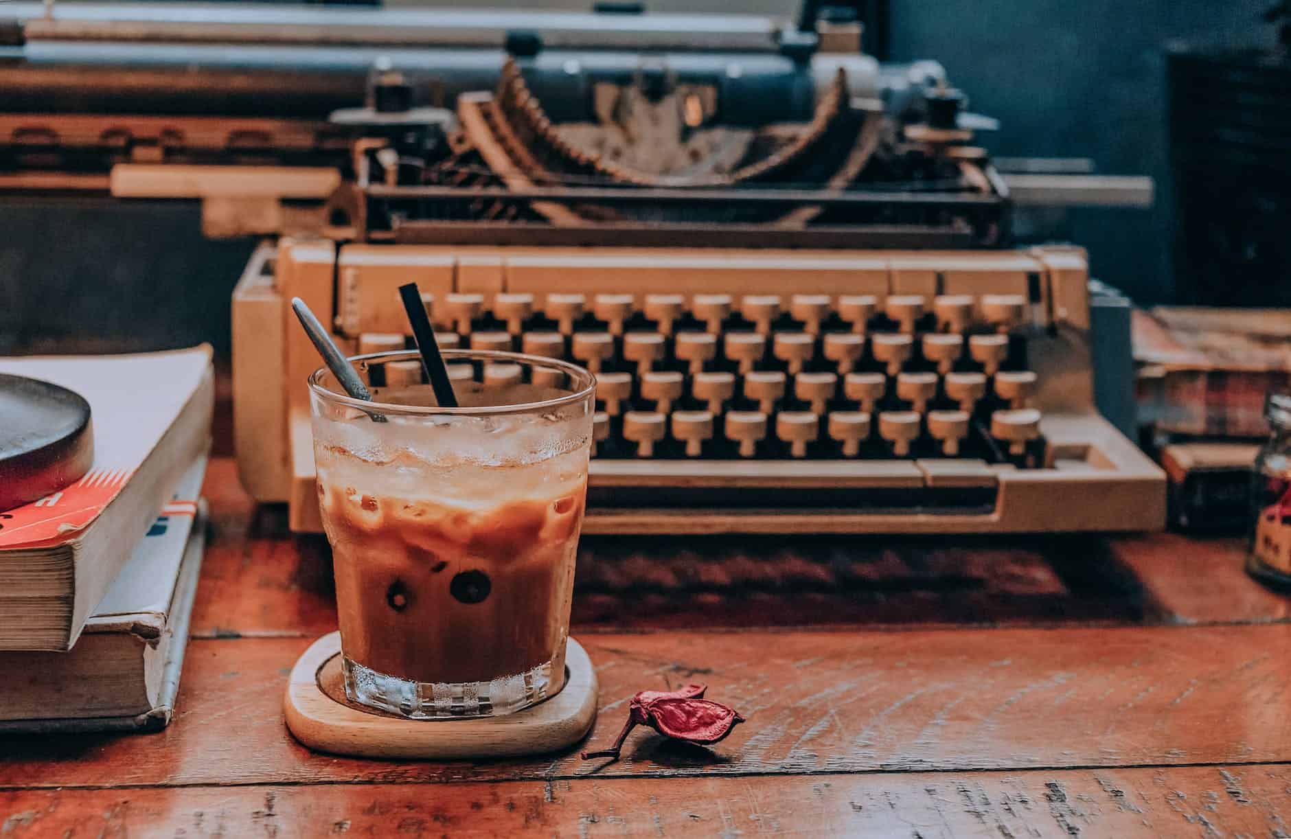 cold coffee in glass near typewriter