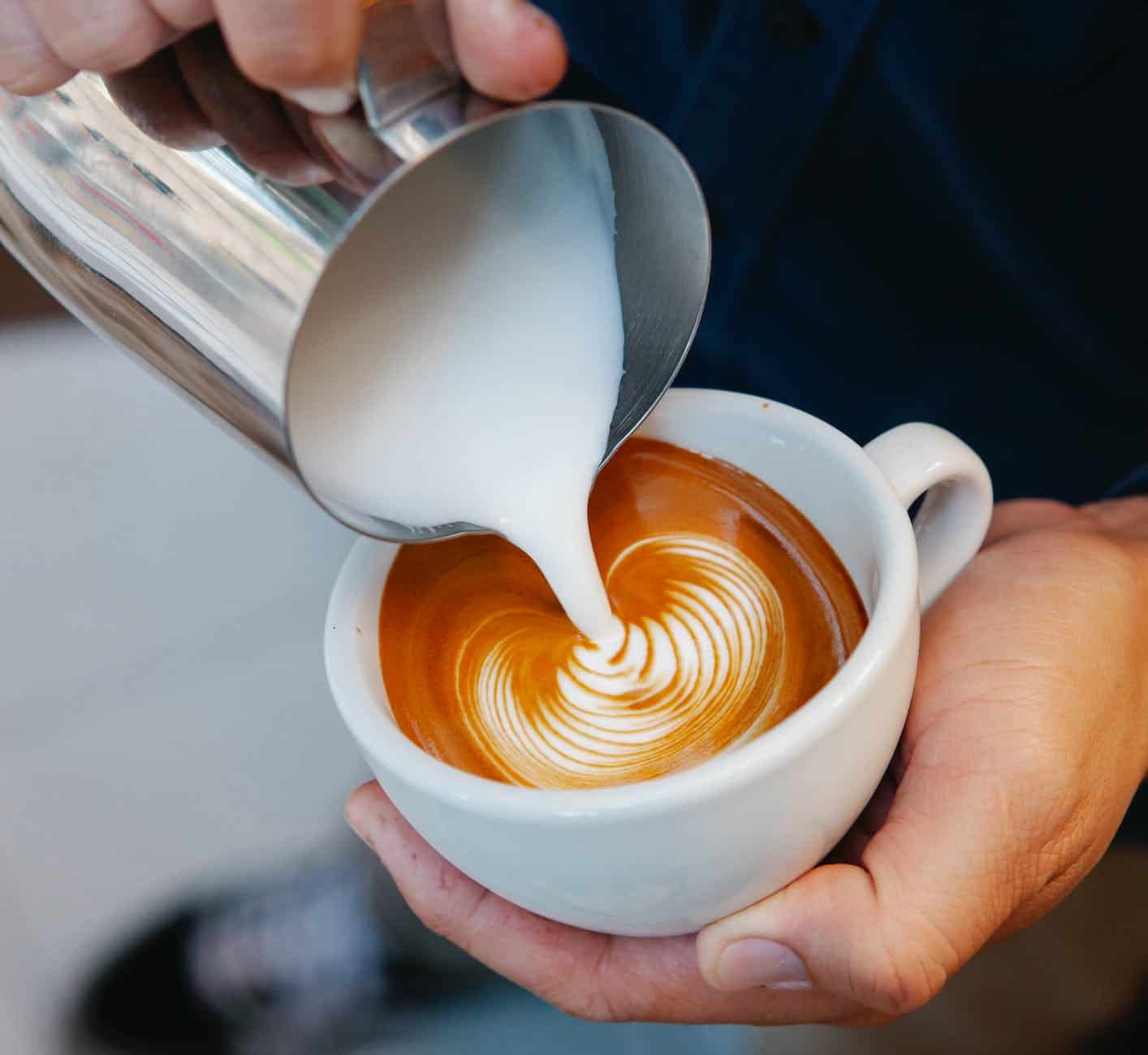 faceless barista preparing delicious latte in coffee house
