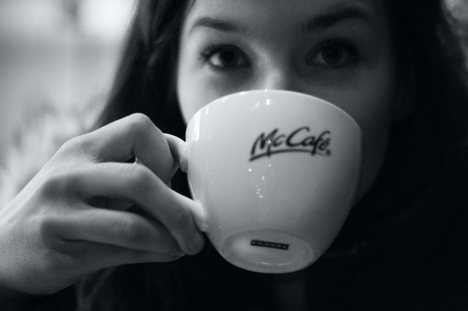 grayscale photography of woman drinking coffee