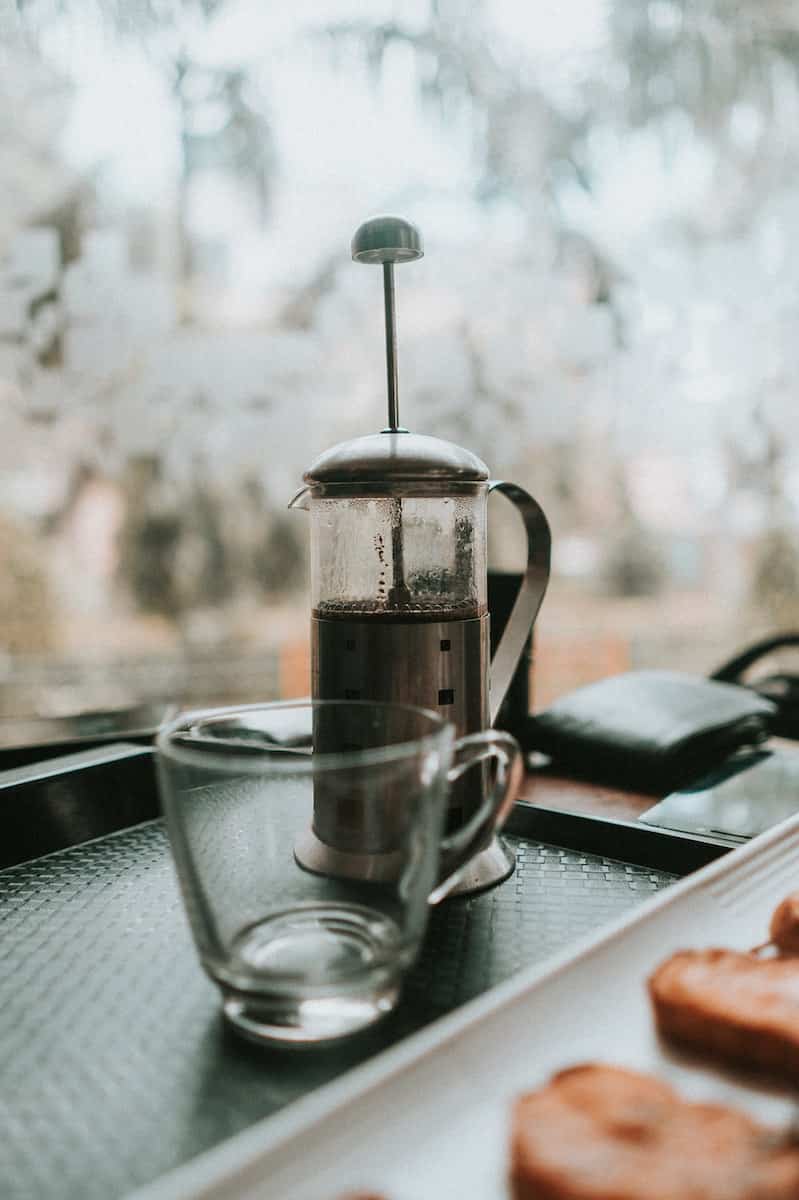 Empty Cup Beside Coffee Press