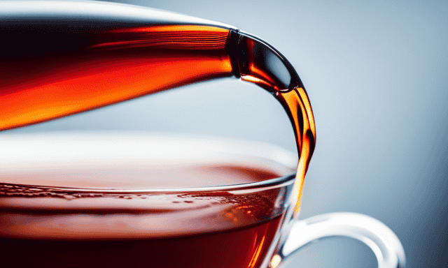 An image showcasing the vibrant crimson hue of freshly brewed Rooibos tea, pouring gently into a delicate, clear glass teacup