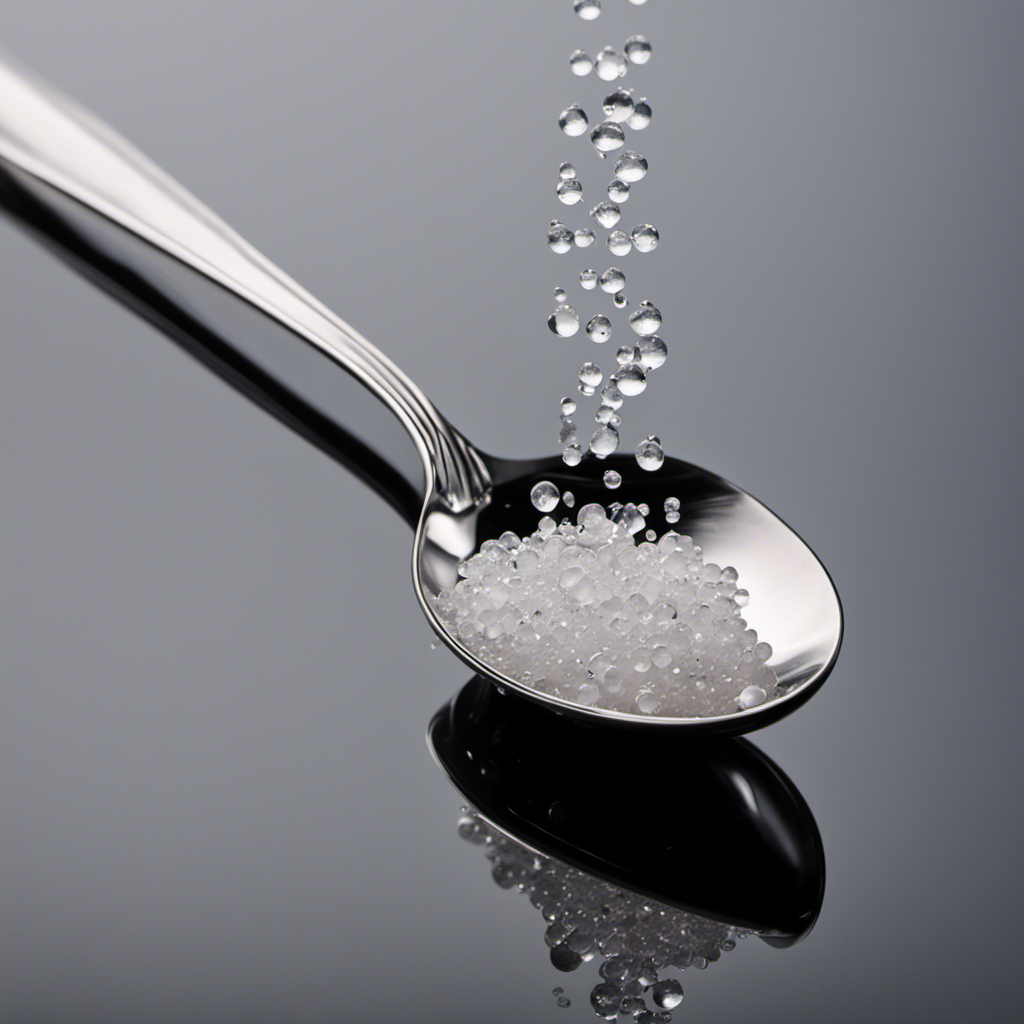 An image depicting a teaspoon filled with tiny salt crystals, while a droplet of water hovers above it
