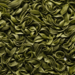 An image showcasing a close-up of delicate, curled oolong tea leaves, tightly wrapped like miniature scrolls, unfurling slowly in a steaming cup